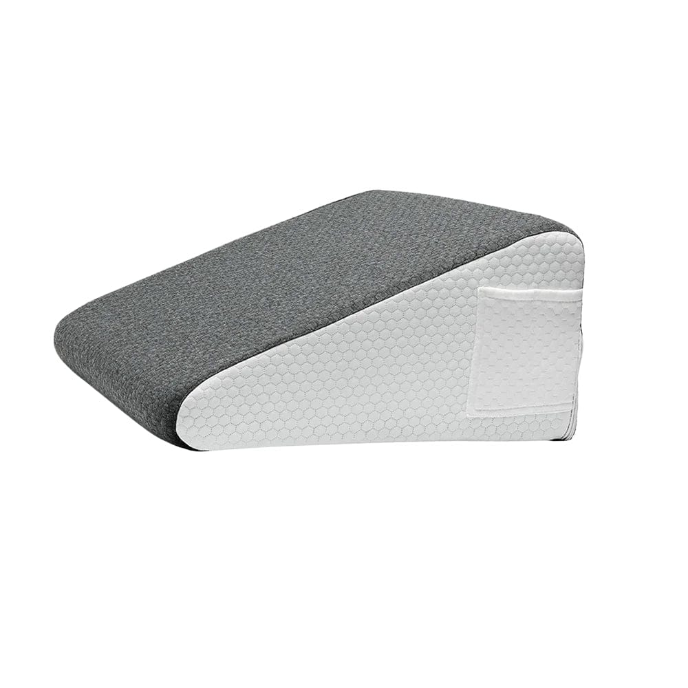 Coussin anti-reflux adulte en tissu gris avec une base blanche, posé sur un lit