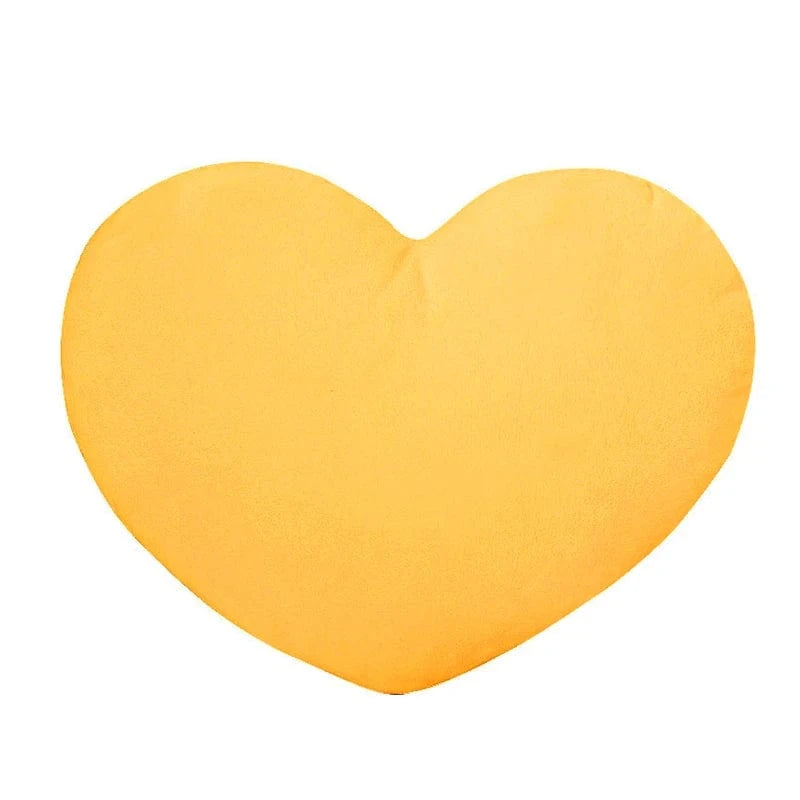 Coussin décoratif en forme de cœur, doux et jaune, posé sur un canapé moderne