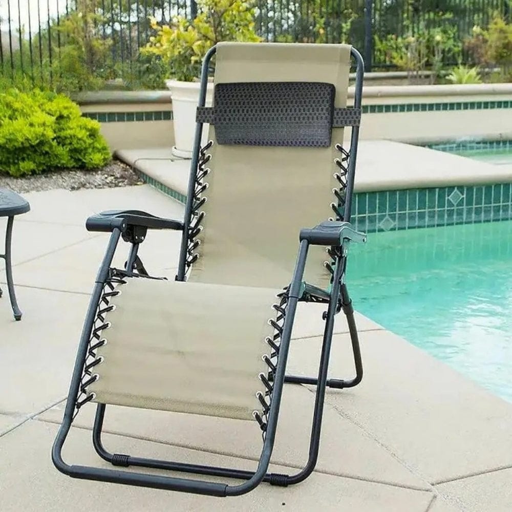 Coussin de tête noir sur une chaise longue beige à côté d'une piscine, décor extérieur moderne et élégant
