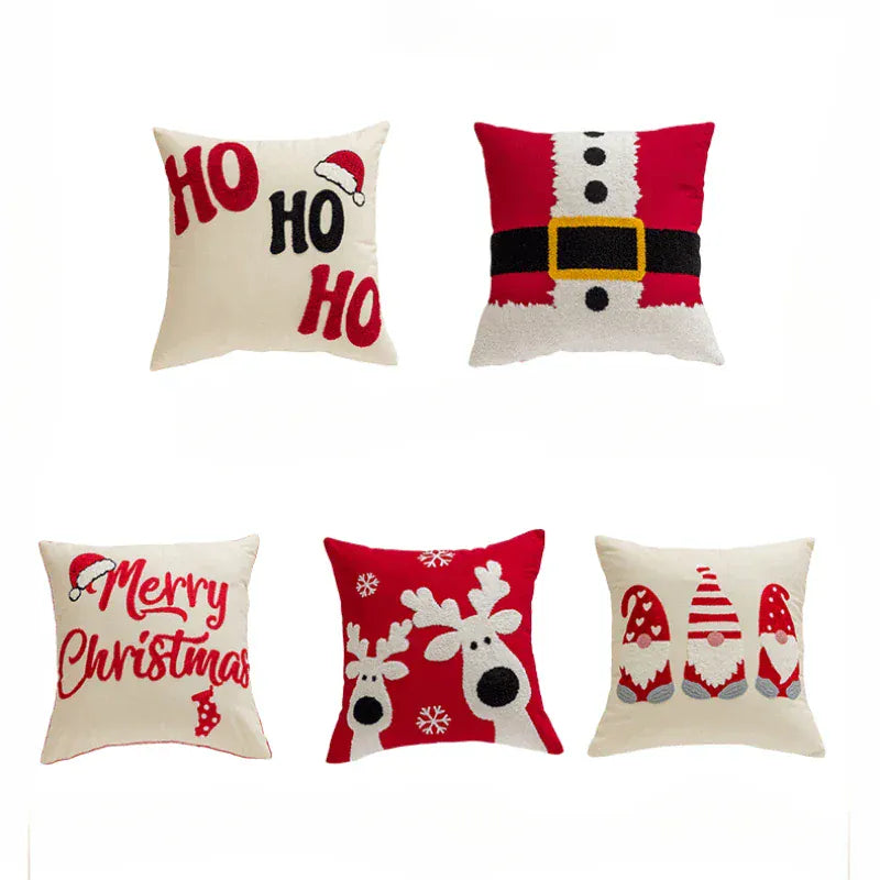 Coussins décoratifs aux motifs de Noël, couleurs rouge et blanc, posés sur un canapé moderne