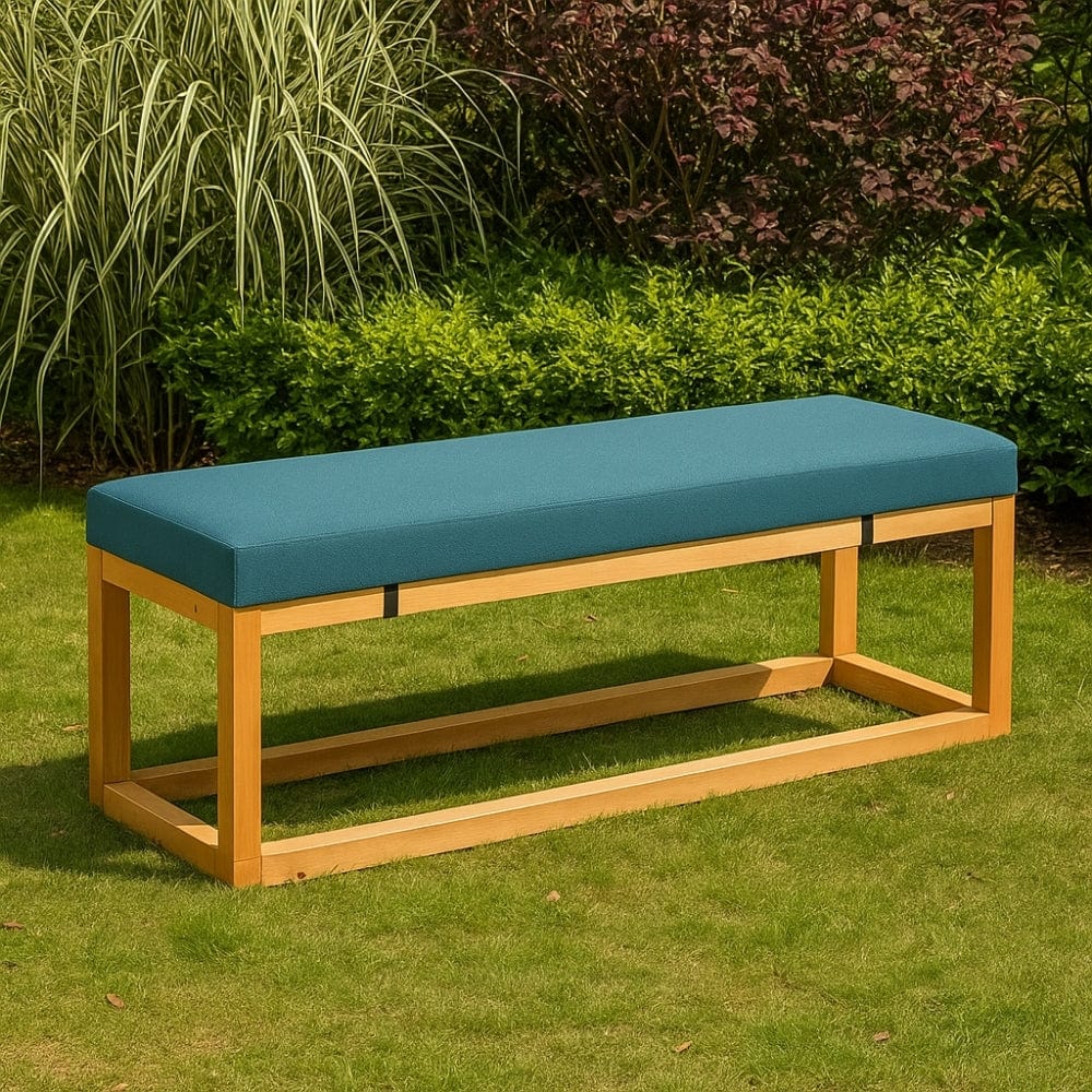 Coussin de banquette de jardin en tissu bleu, posé sur une structure en bois, entouré de verdure