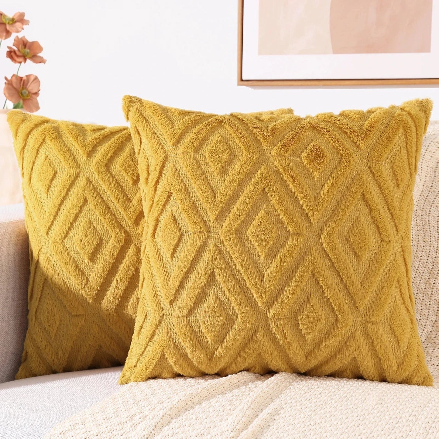 Coussins décoratifs en velours doux jaune avec motifs géométriques, posés sur un canapé clair dans un salon élégant