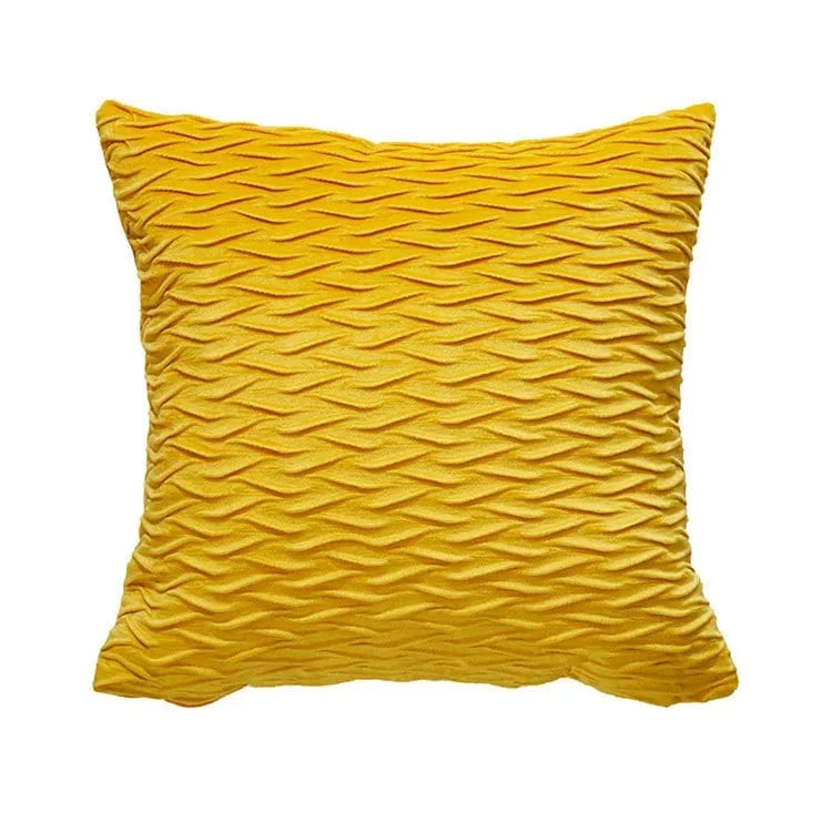 Coussin décoratif en velours jaune, au motif ondulé, posé sur un canapé moderne pour une ambiance chaleureuse