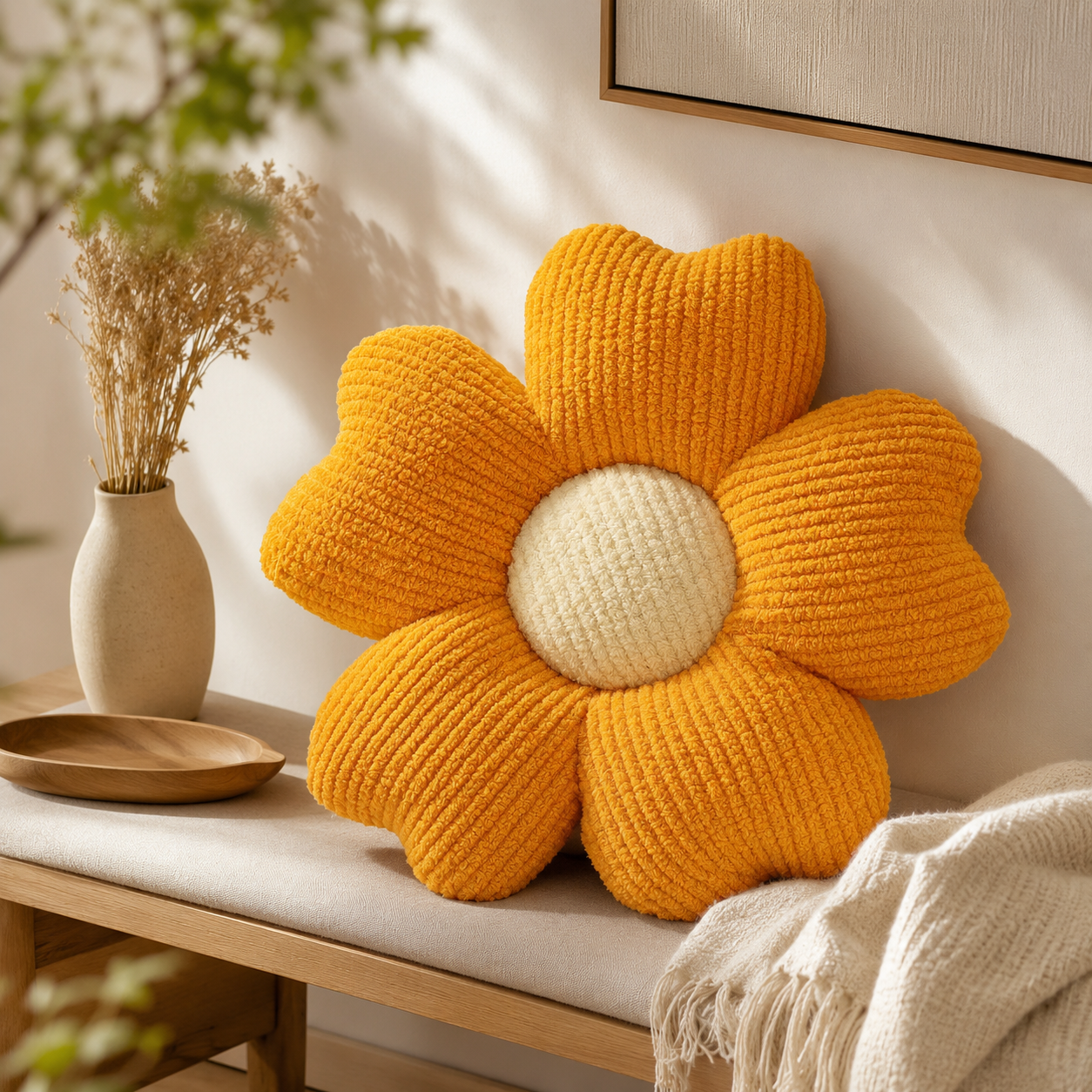 Coussin orange en forme de fleur à cinq pétales posé sur un banc en bois dans une décoration naturelle et chaleureuse.