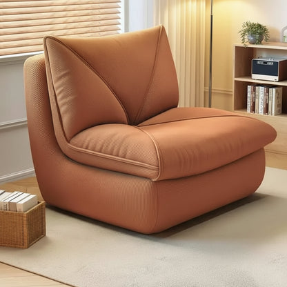 Fauteuil pouf salon en velours côtelé marron caramel installé dans un salon cosy