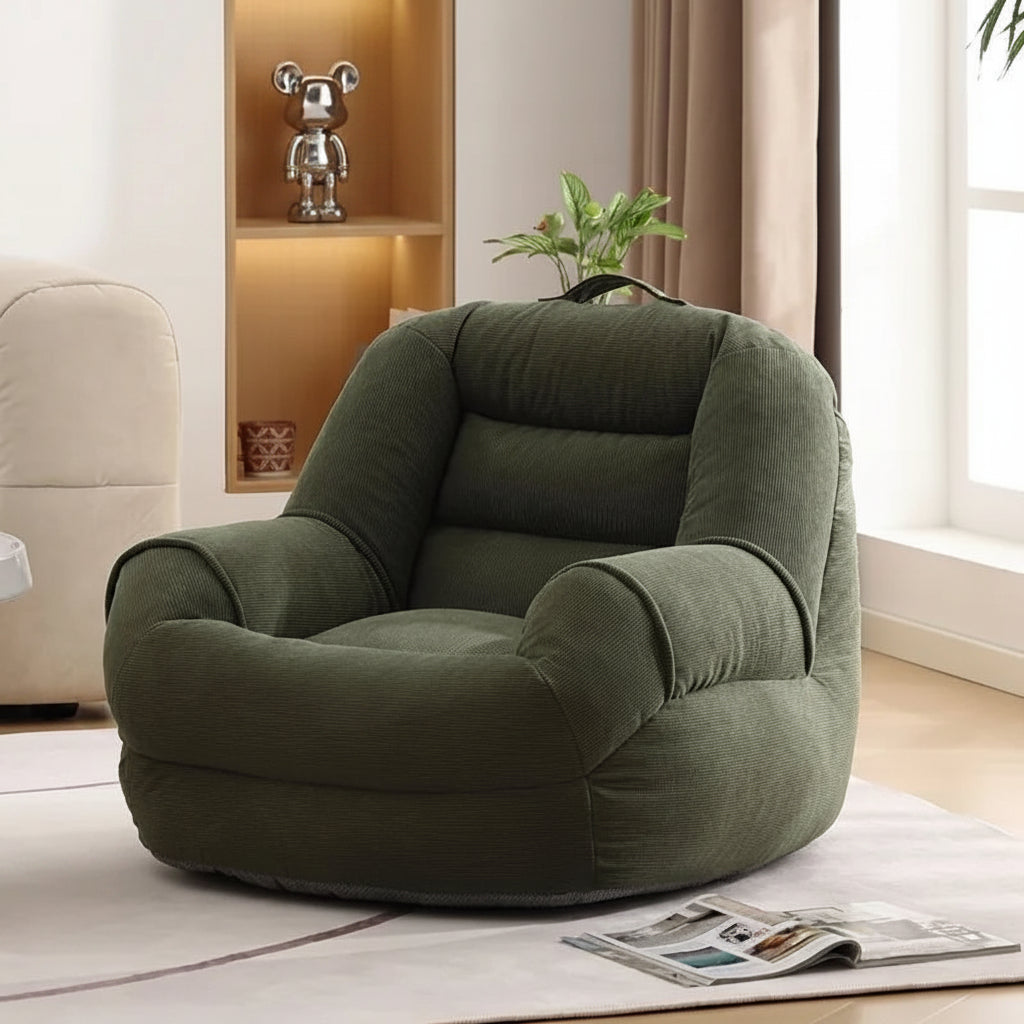 Fauteuil pouf en velours côtelé vert olive, vu de trois quarts dans un salon.