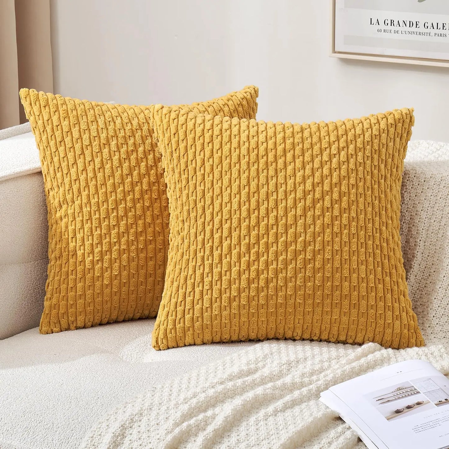 Deux housses de coussin jaune moutarde à relief côtelé présentées sur un canapé clair.