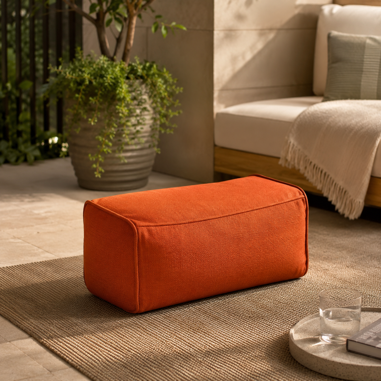 Pouf extérieur résistant rectangulaire orange terracotta installé sur une terrasse