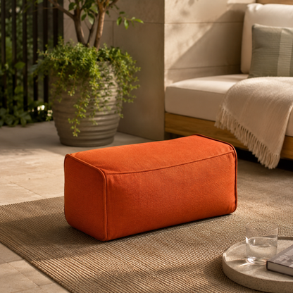 Pouf extérieur résistant rectangulaire orange terracotta installé sur une terrasse