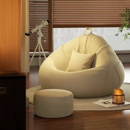 Pouf poire géant crème avec repose-pieds installé dans un coin détente