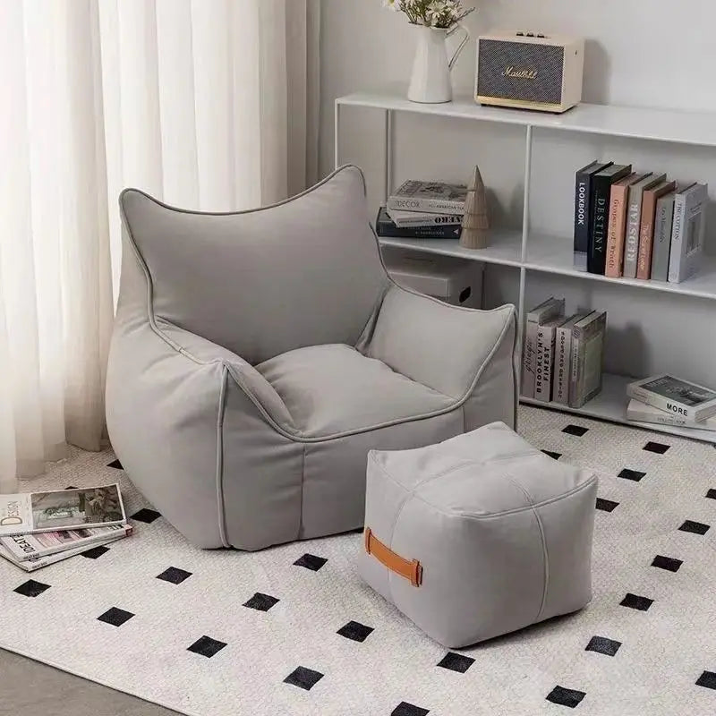 Pouf salon en tissu gris clair avec repose-pieds assorti dans un intérieur moderne