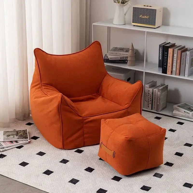 Pouf salon en tissu orange brique avec repose-pieds assorti dans une pièce de vie