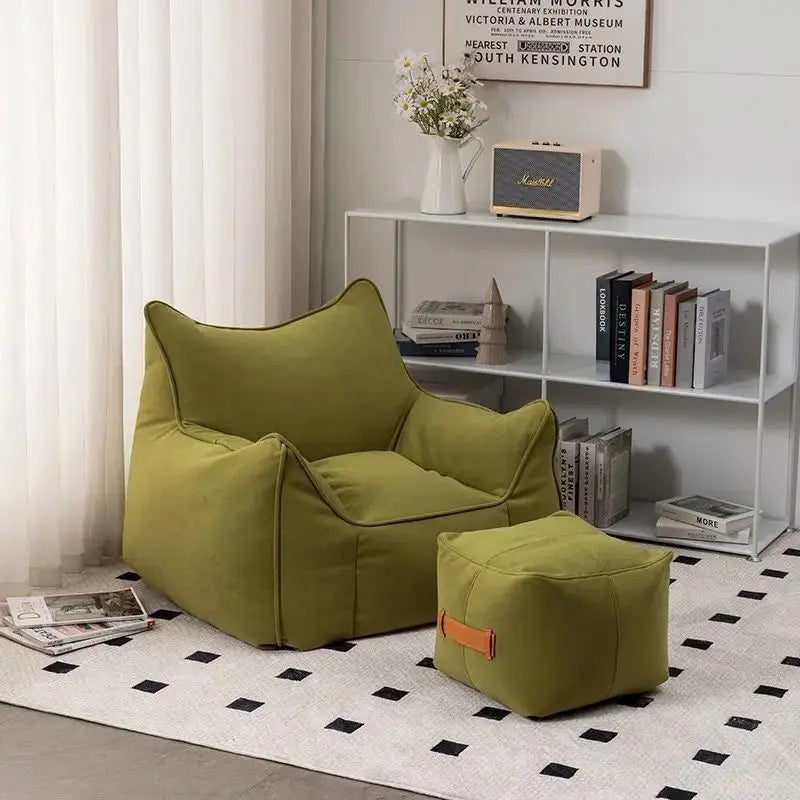 Pouf salon en tissu vert olive avec repose-pieds assorti dans un salon