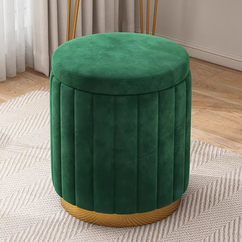 Vue légèrement en plongée du pouf vert en velours avec assise ronde, coutures verticales et base dorée.