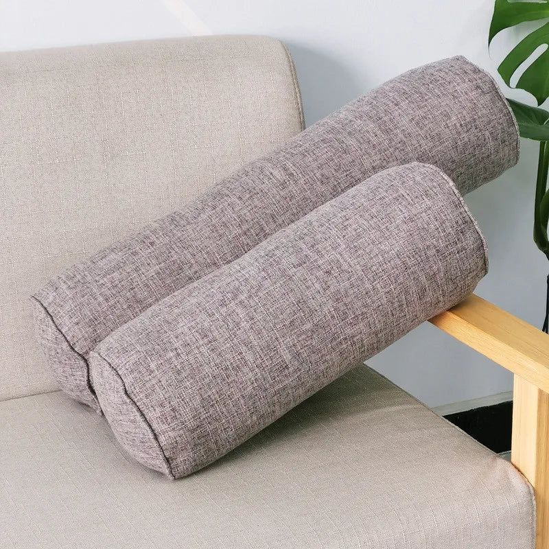 Deux coussins boudins gris clair en tissu chiné, de longueurs différentes, sur un fauteuil