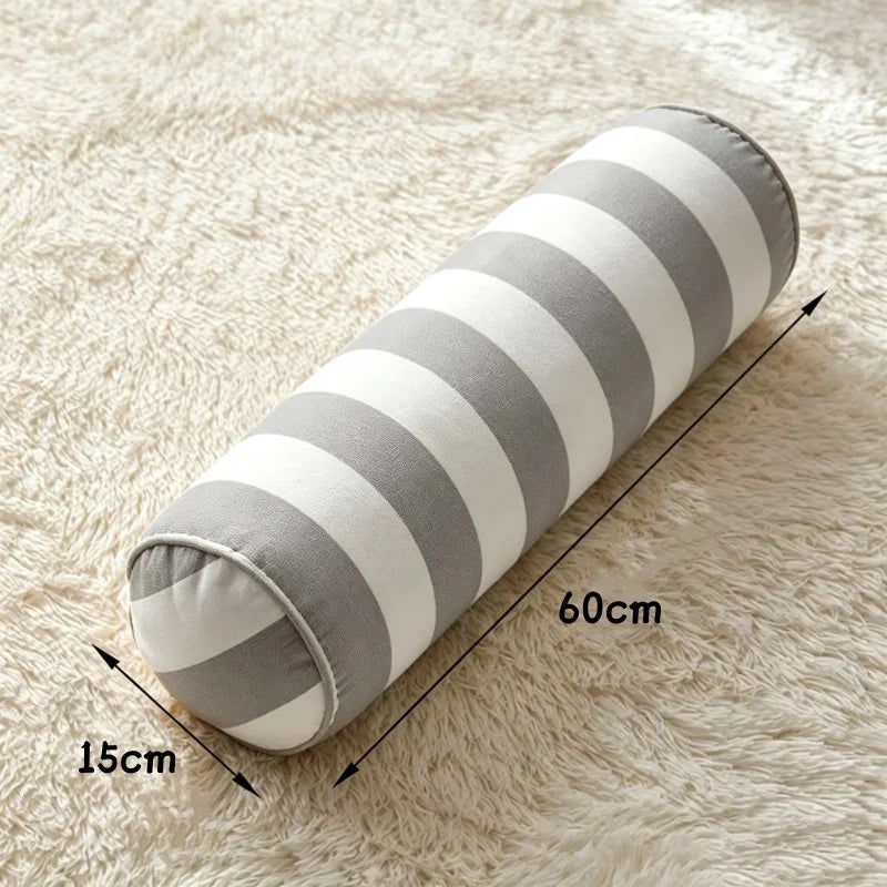 Coussin cylindrique à rayures grises et blanches, de 60 cm de longueur et 15 cm de diamètre.