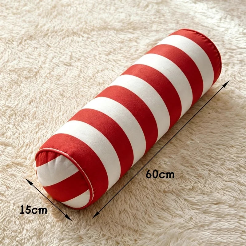 1. Coussin cylindrique à rayures rouges et blanches, de 60 cm de longueur et 15 cm de diamètre.
