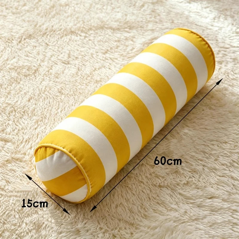 Coussin cylindrique à rayures jaunes et blanches, de 60 cm de longueur et 15 cm de diamètre.