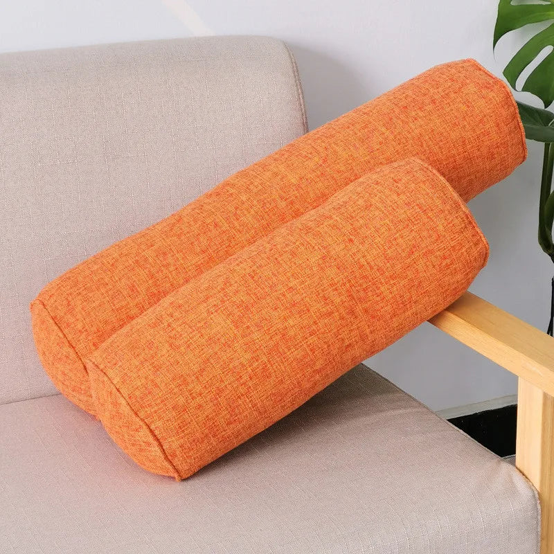 Coussins cylindriques orange en deux longueurs sur un fauteuil à accoudoirs en bois
