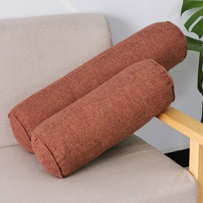 Deux coussins boudins marron en tissu chiné posés sur un fauteuil beige