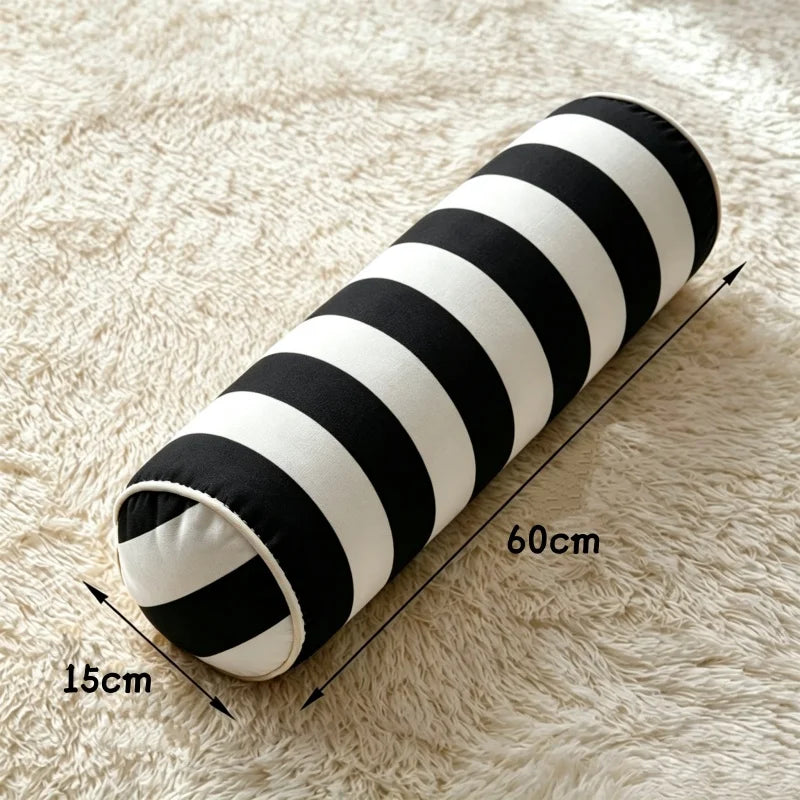Coussin cylindrique à rayures noires et blanches, de 60 cm de longueur et 15 cm de diamètre.