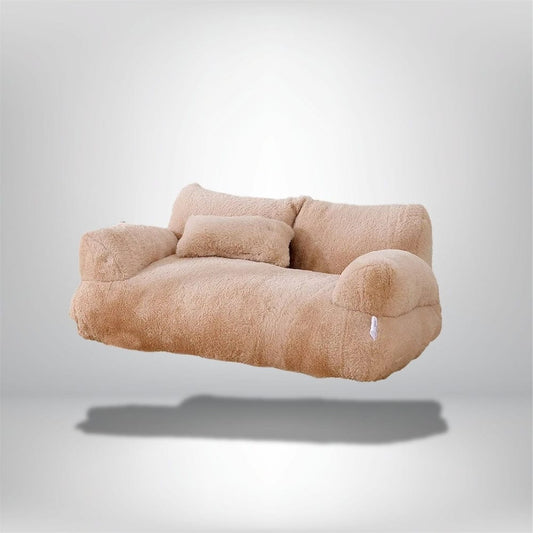 Coussin décoratif beige en matière douce, posé sur un canapé moderne au design épuré