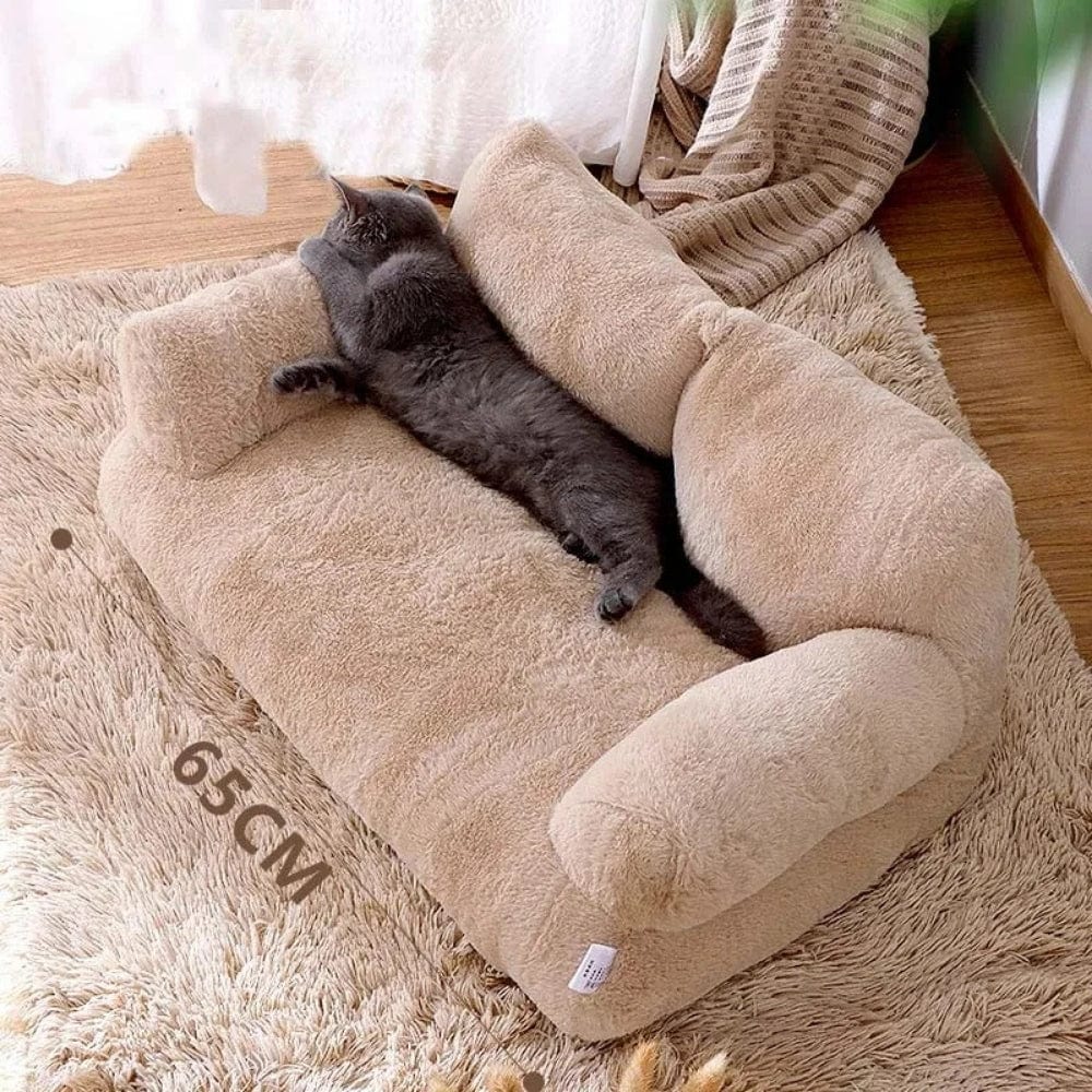 Coussin décoratif beige en peluche, avec accoudoirs, posé sur un tapis moelleux dans un salon