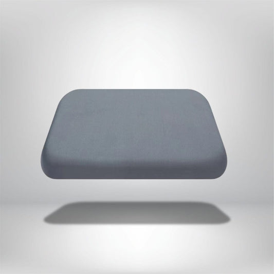 Coussin décoratif en mousse à mémoire de forme de couleur grise, posé sur un fond neutre