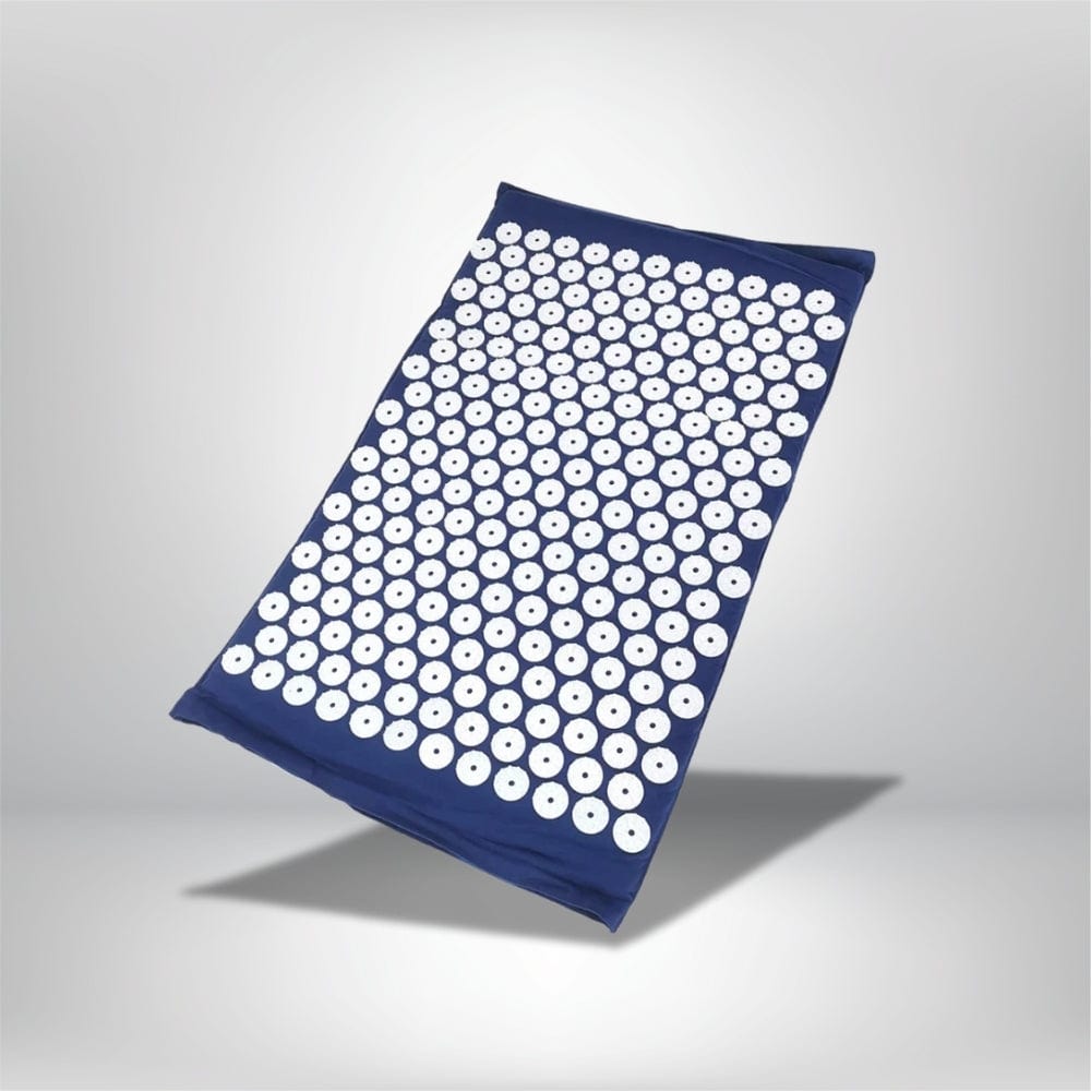 Coussin acupression bleu marine avec des disques blancs, posé sur un fond neutre, idéal pour le bien-être