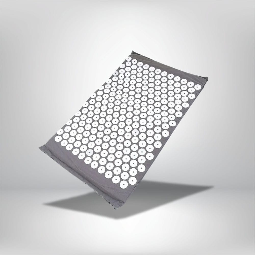 Coussin de relaxation gris avec des disques blancs, posé sur un fond neutre, idéal pour le bien-être