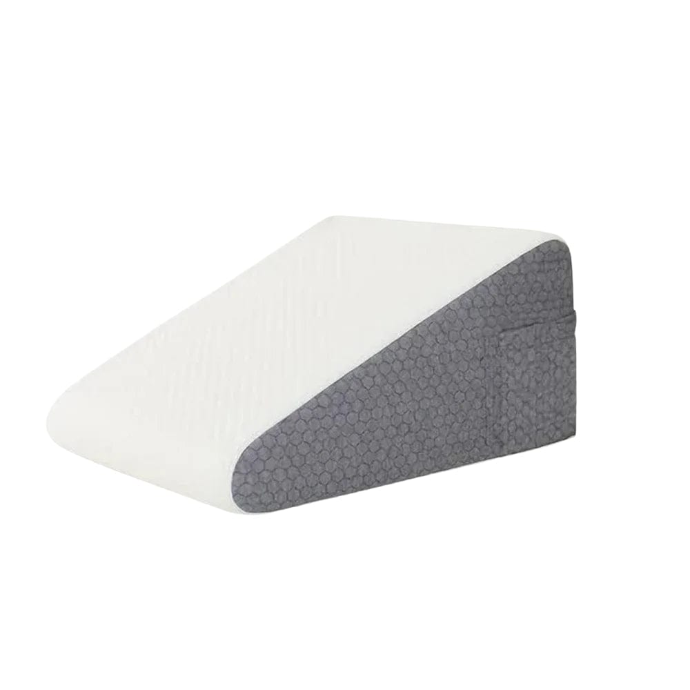 Coussin anti-reflux en mousse, de forme inclinée, avec une face blanche et une face grise, posé sur un lit