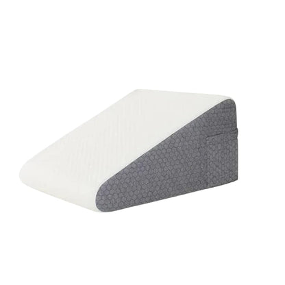 Coussin anti-reflux en mousse, de forme inclinée, avec une face blanche et une face grise, posé sur un lit