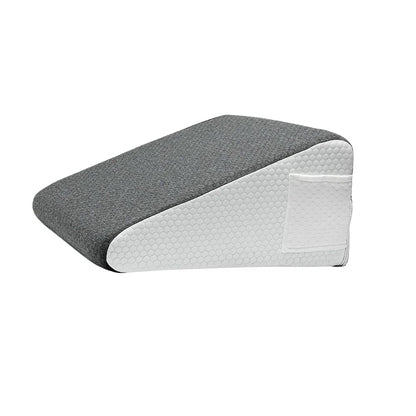 Coussin anti-reflux adulte en tissu gris avec une base blanche, posé sur un lit