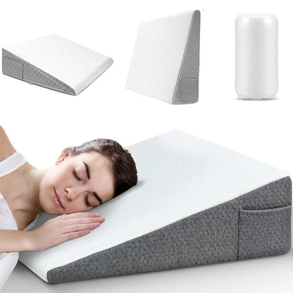 Coussin anti-reflux en mousse, de forme triangulaire, posé sur un lit avec une housse blanche et grise