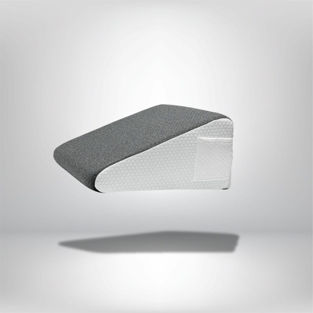 Coussin anti-reflux adulte en tissu gris avec une base blanche, posé sur un fond neutre