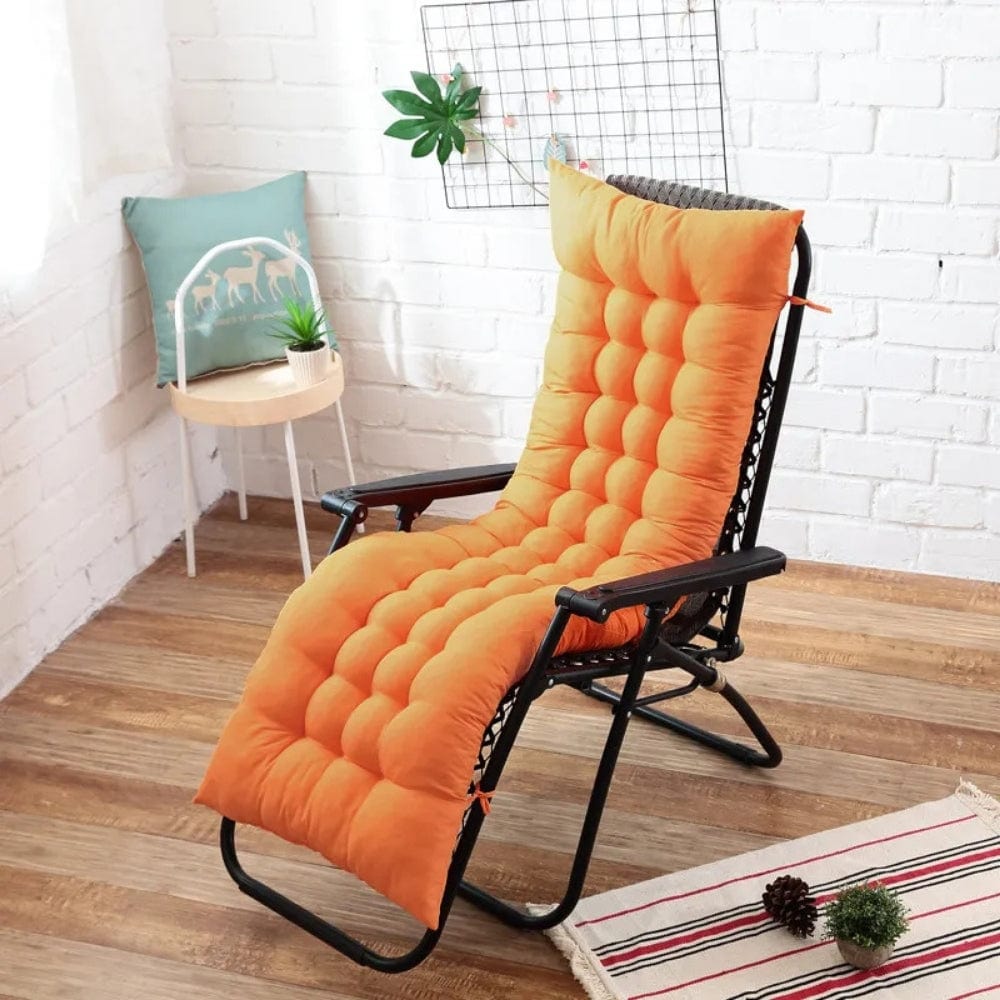 Coussin bain de soleil épais orange avec un motif matelassé, posé sur une chaise noire dans un intérieur lumineux