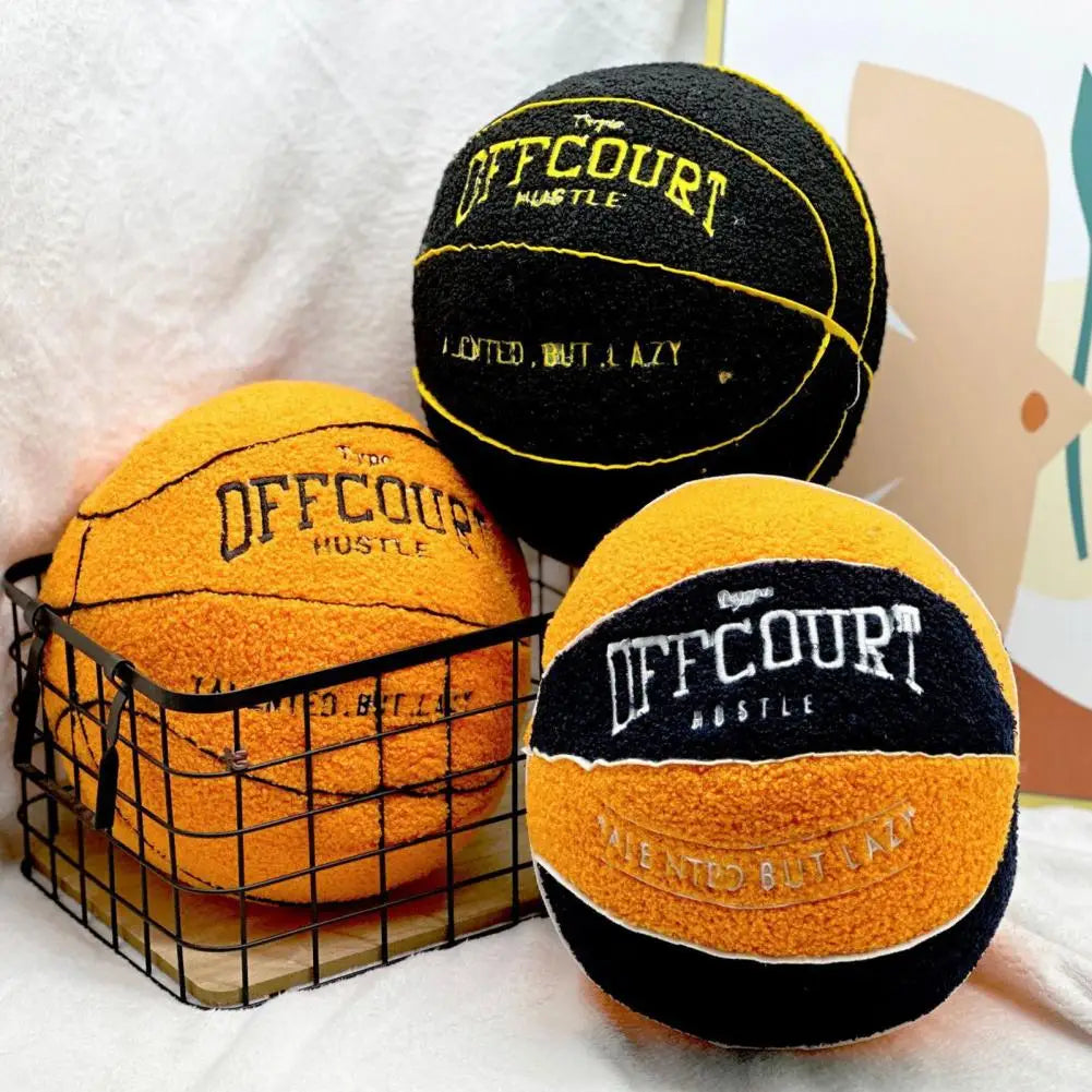 Coussins décoratifs en forme de ballon de basket orange et noir, posés dans un panier en métal