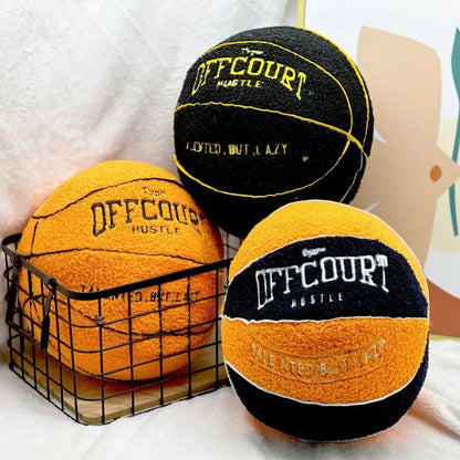 Coussins décoratifs en forme de ballon de basket orange et noir, posés dans un panier en métal