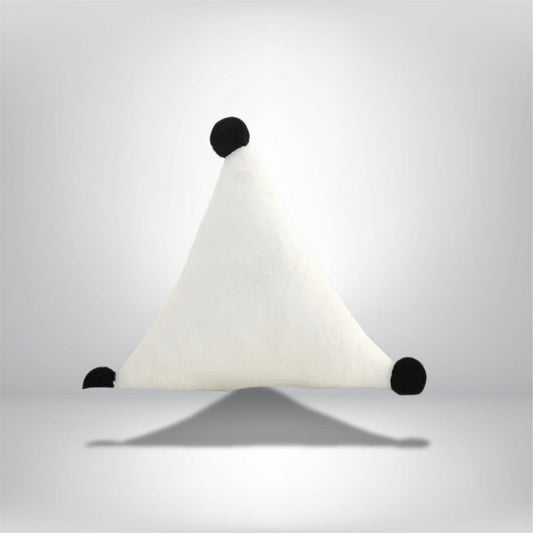 Coussin décoratif blanc en forme de triangle avec des pompons noirs, posé sur une surface neutre