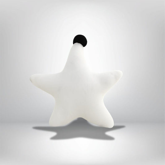Coussin décoratif en forme d'étoile, blanc avec un petit pompon noir, sur un fond neutre