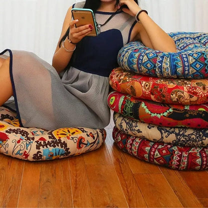 Coussins décoratifs ronds aux motifs colorés, disposés sur un sol en bois, créant une ambiance bohème