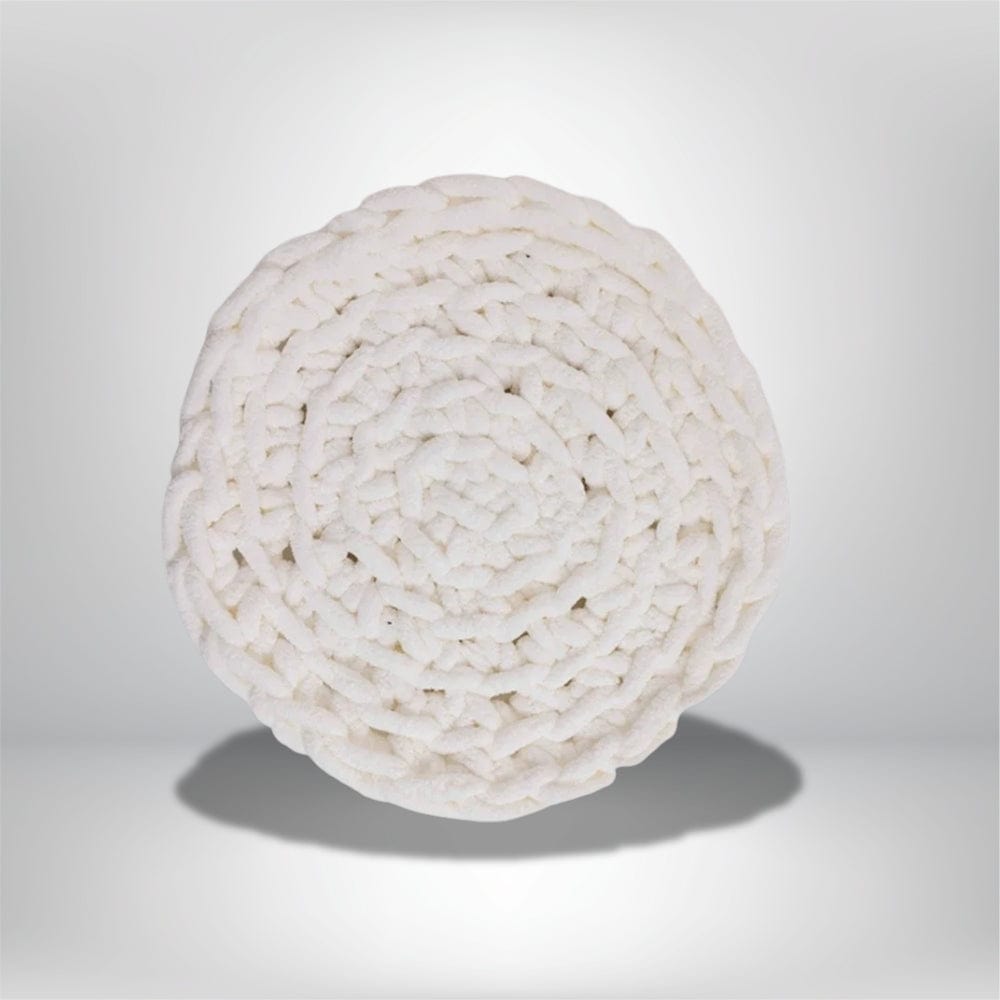 Coussin décoratif rond en tissu blanc, avec un motif tressé, posé sur un fond neutre