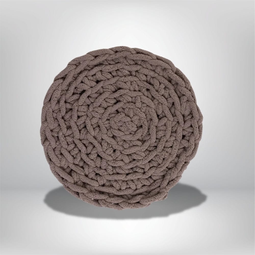 Coussin déco rond en tissu tressé couleur taupe, posé sur un fond neutre, idéal pour un salon moderne