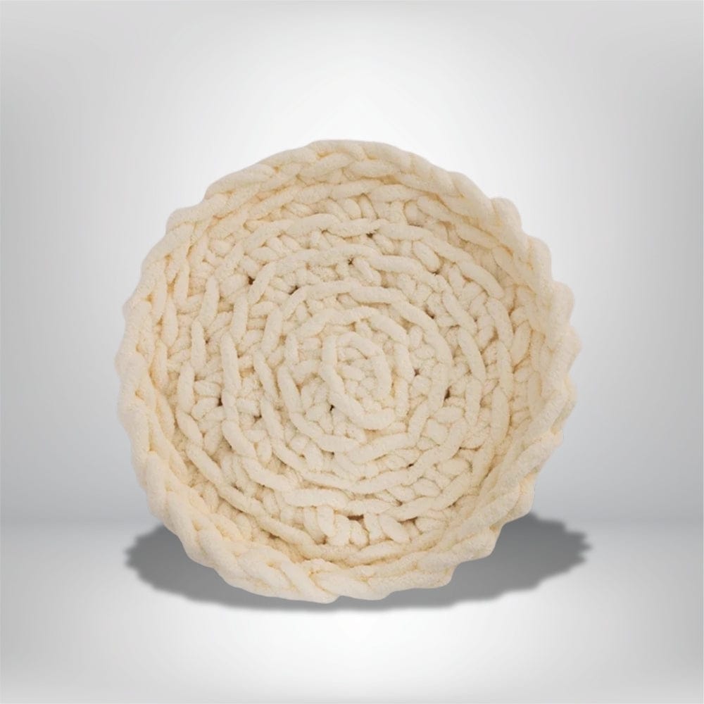 Coussin déco rond en tissu beige avec un motif tressé, posé sur une surface neutre