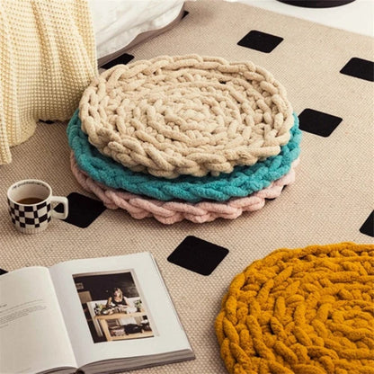 Coussins décoratifs ronds en matières douces, couleurs beige, turquoise, rose et jaune, posés sur un tapis dans un salon