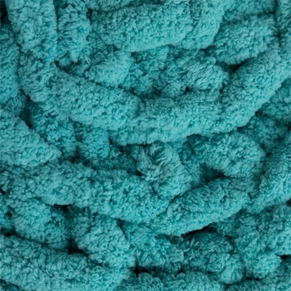 Coussin déco en velours turquoise, avec un motif texturé, idéal pour un canapé ou une chaise