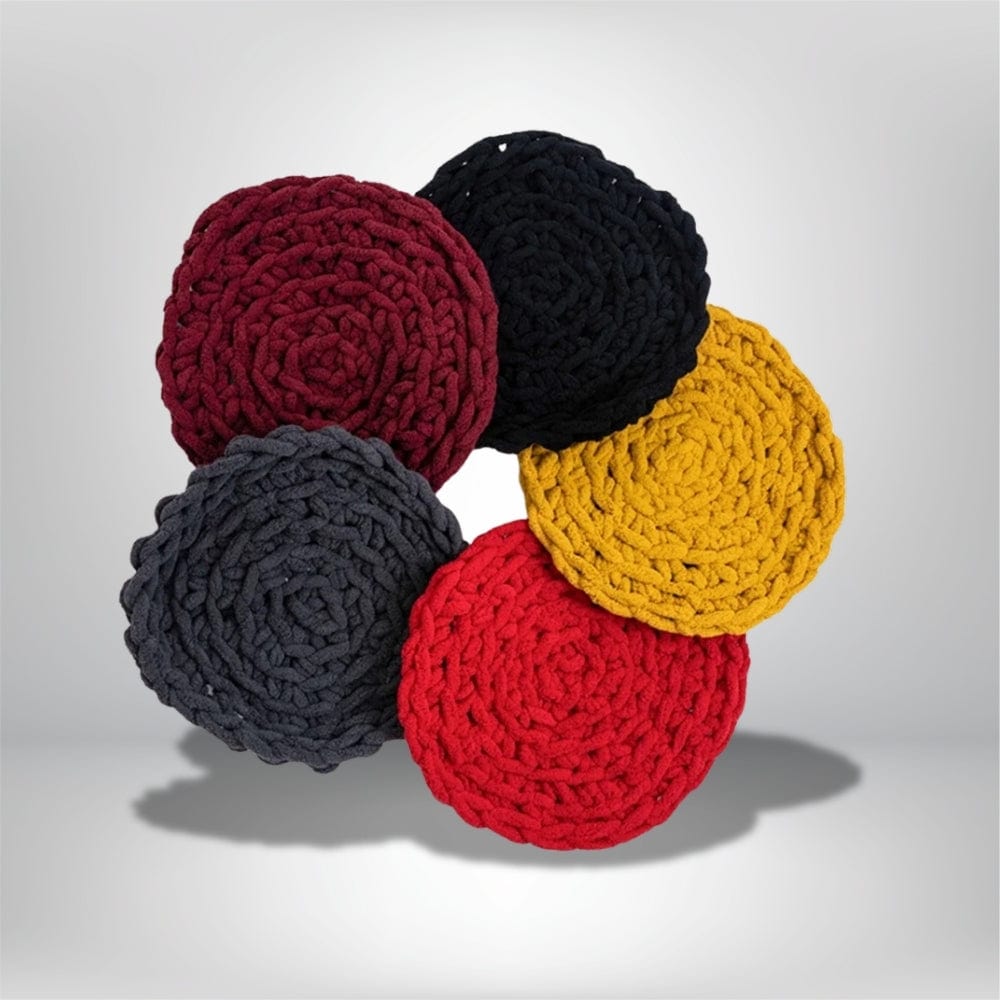 Coussins décoratifs ronds en laine, de couleurs rouge, noir, jaune, gris et bordeaux, sur un fond neutre