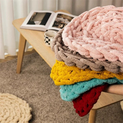 Coussins décoratifs en tissu doux, aux couleurs pastel et vives, posés sur une table en bois dans un salon moderne