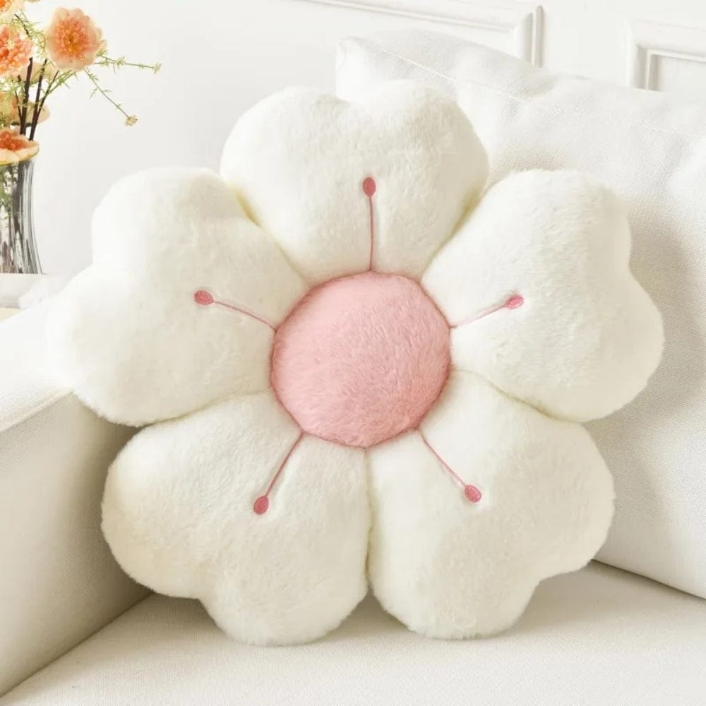Coussin décoratif en forme de fleur, blanc et rose, posé sur un canapé clair dans un salon moderne