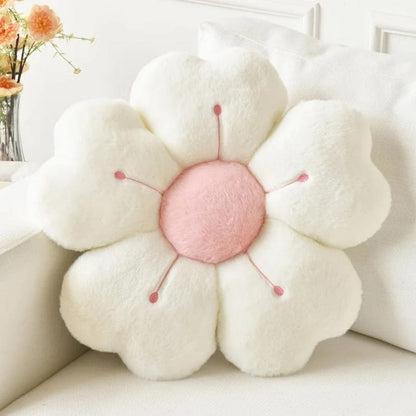 Coussin décoratif en forme de fleur, blanc et rose, posé sur un canapé clair dans un salon moderne